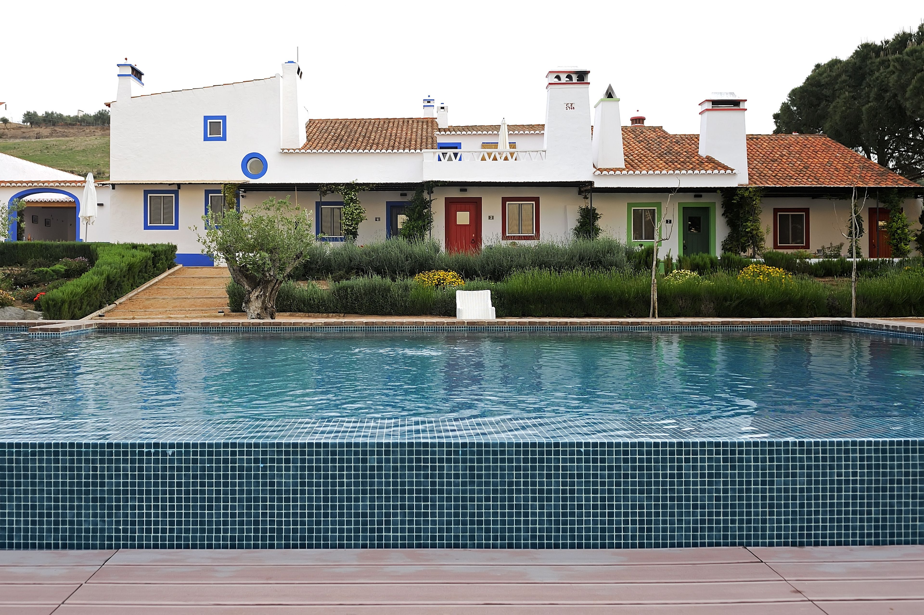 Una piscina al aire libre, sombrillas, tumbonas