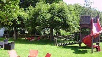 Kids can play on the outdoor play area's slide and climbing structure.