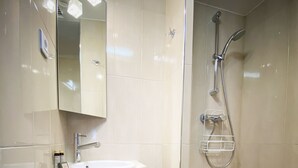 A bathroom with a sink, mirror, towel rack, and shower. - Hotel Molière (Cannes)
