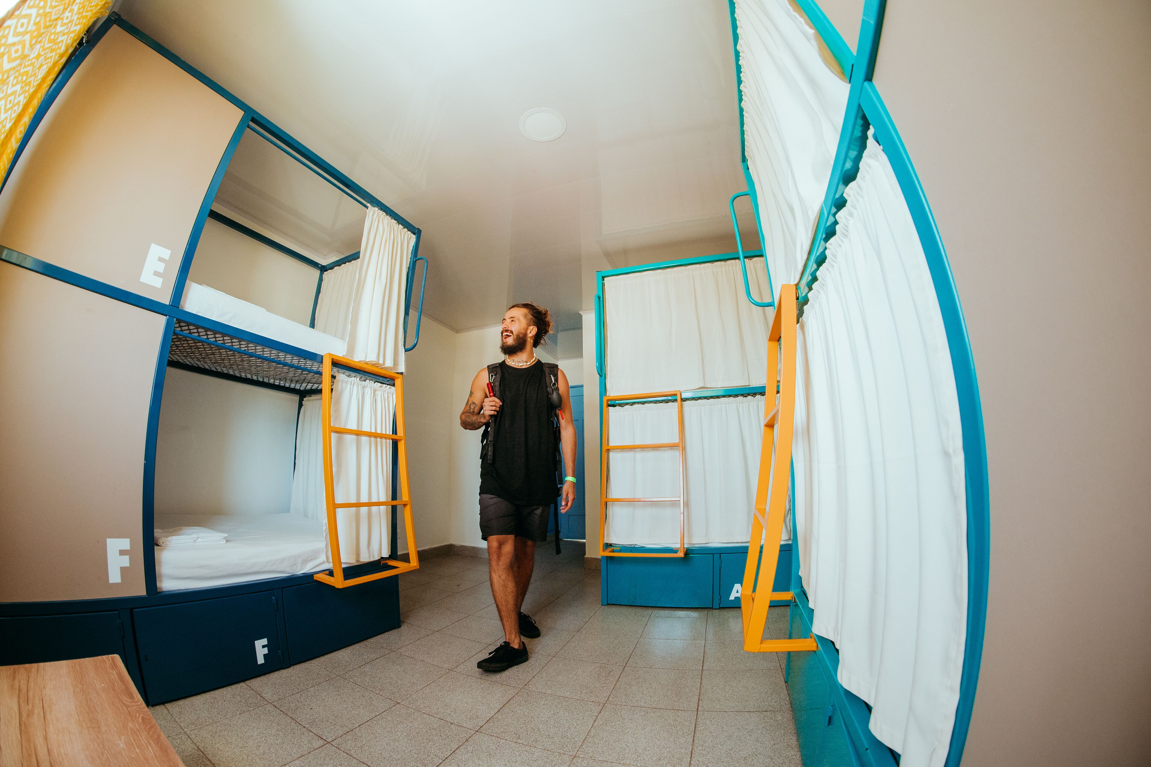 Una camera del dormitorio con letti a castello, un tavolo in legno e una tenda.