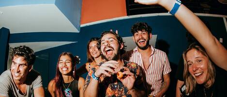 A group of people in a room with a large geometric wall design.