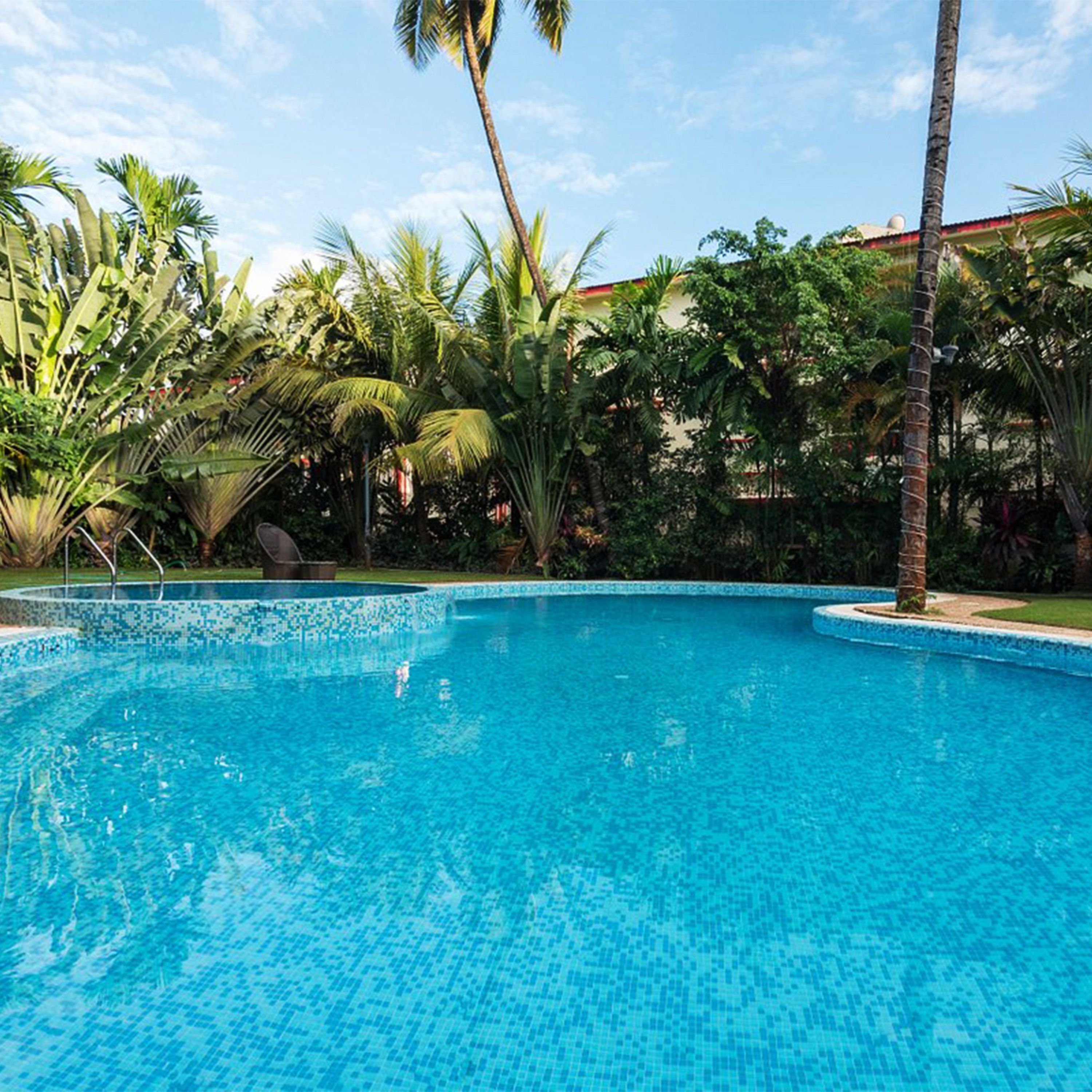 Una piscina al aire libre, sombrillas, sillones reclinables de piscina