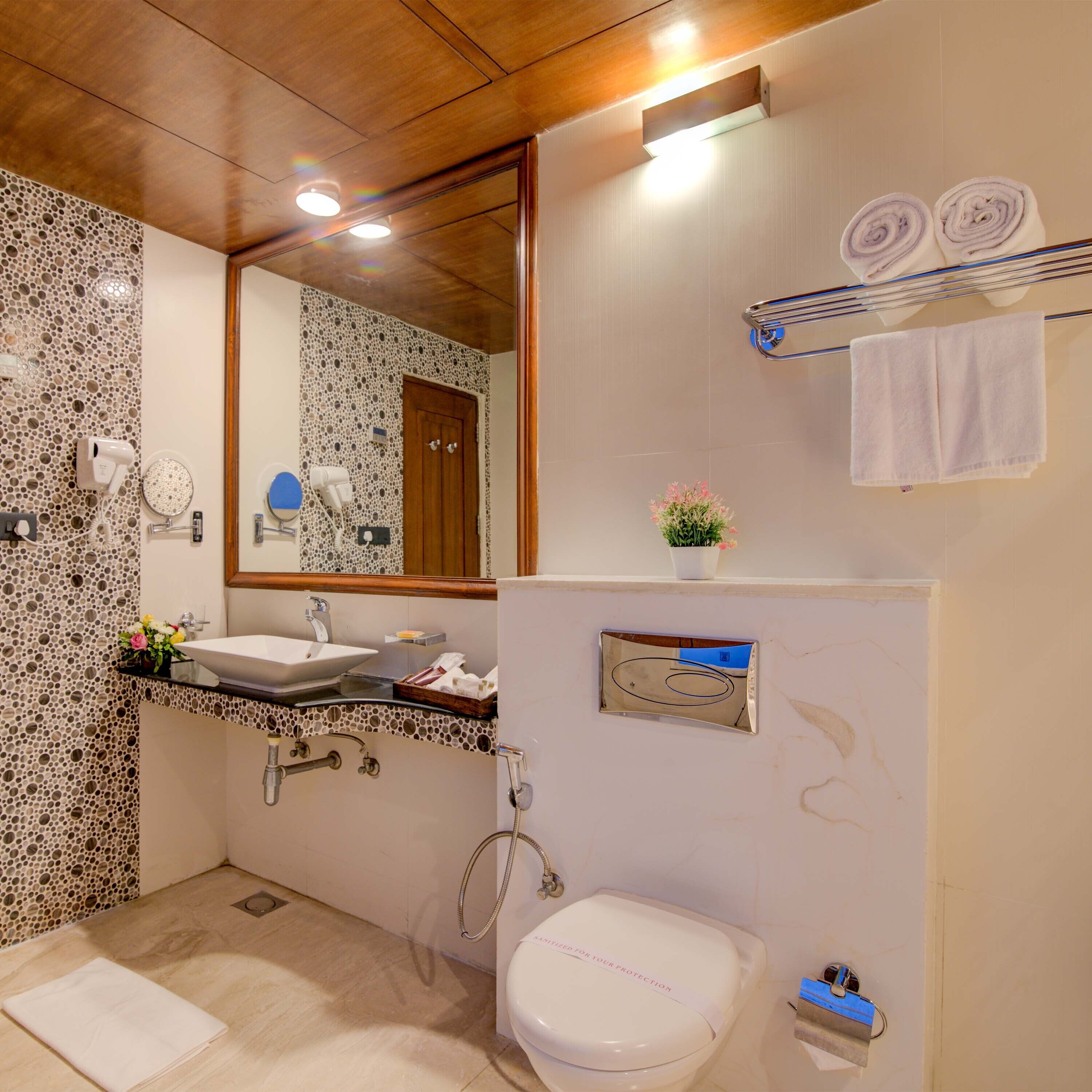 A bathroom with a sink, mirror, towel rack, and toilet.