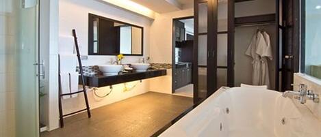 A modern bathroom with a large bathtub, a vanity with a sink, and a mirror.