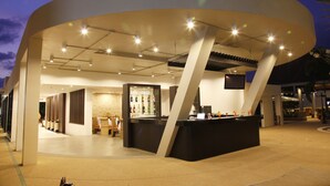 A modern bar area with a curved ceiling and multiple light fixtures.