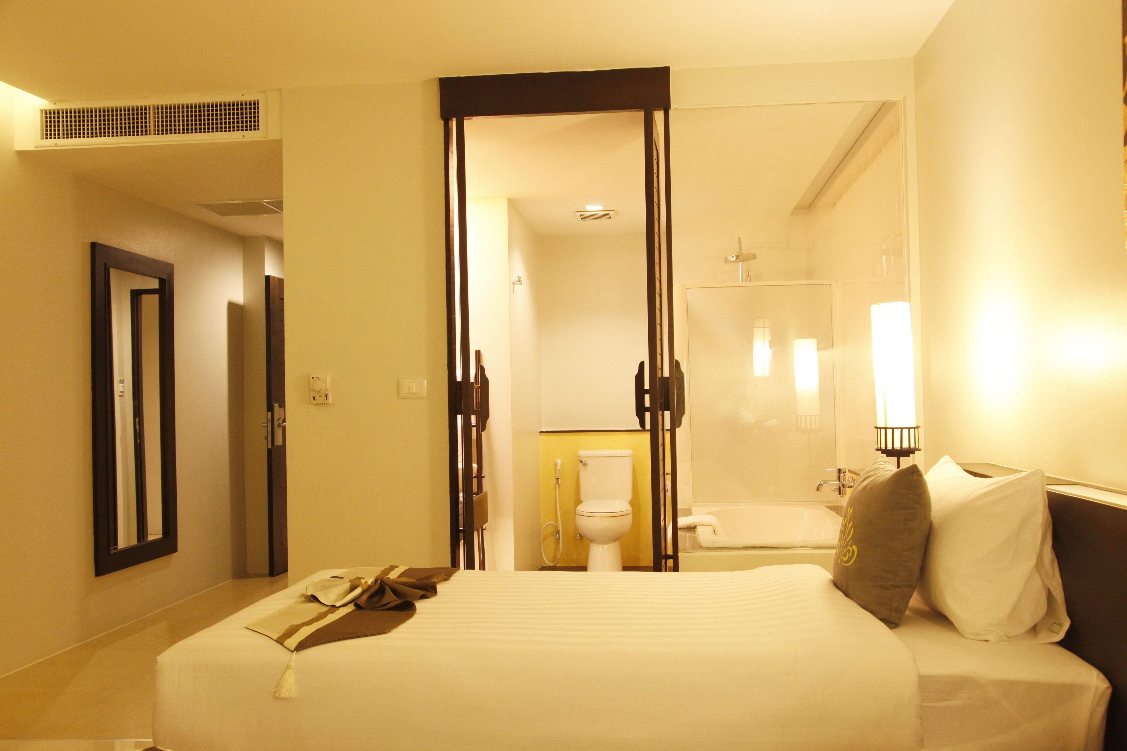 Una camera d'albergo con un letto, un bagno con vasca e un water.