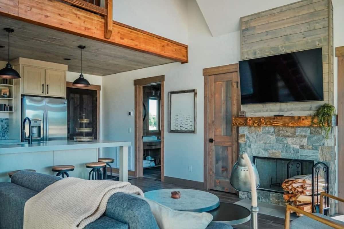 A spacious living area with a fireplace, a kitchen with modern appliances, and a cozy seating area.
