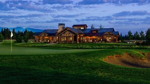 A large, multi-story lodge with a well-maintained lawn and a golf course in the foreground. - Wilderness Club (Eureka)