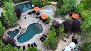 A landscaped outdoor area with a swimming pool, lounge chairs, and a covered seating area. - Wilderness Club (Eureka)