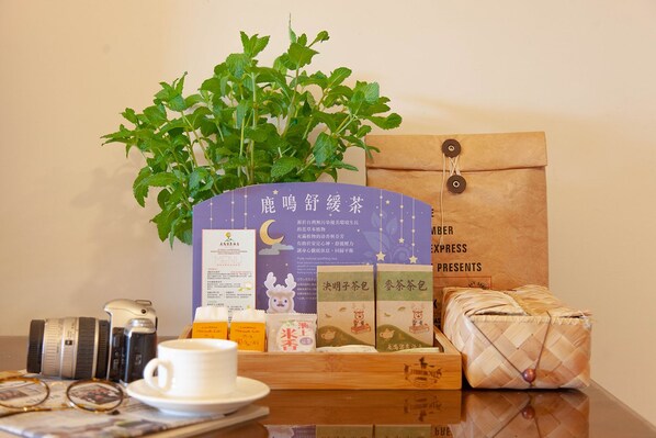 Une table avec une plante, un menu, des paquets de thé et une tasse.