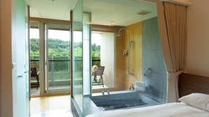 A modern hotel room with a large glass door leading to a balcony, a separate shower area, and a large bathtub. - Luminous Hot Spring & Resort (Luye)