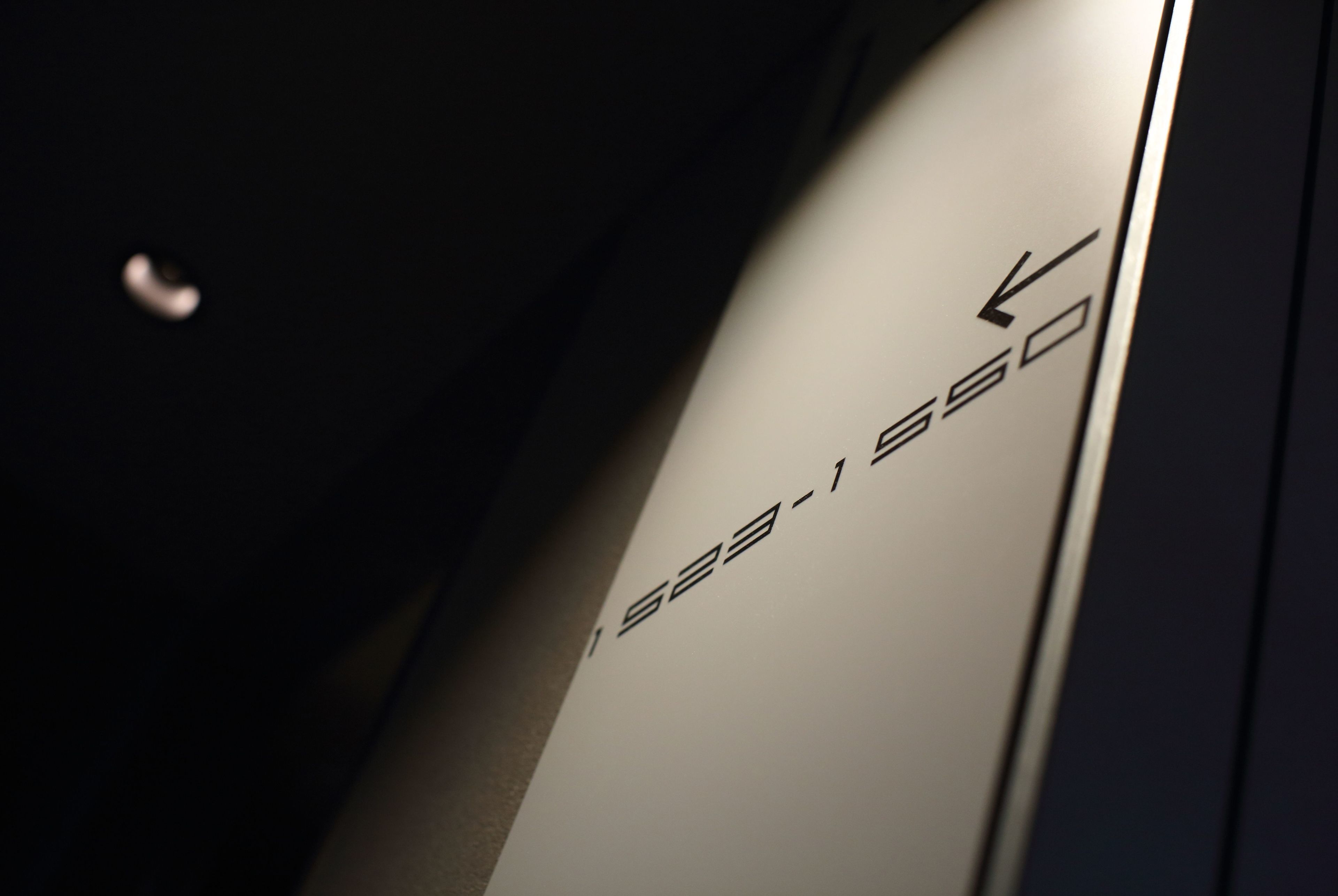 A close-up of a metallic surface with the text "323-550" and an arrow pointing to the right.