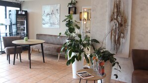 Una sala moderna con una mesa redonda, un sofá y varias plantas en macetas.