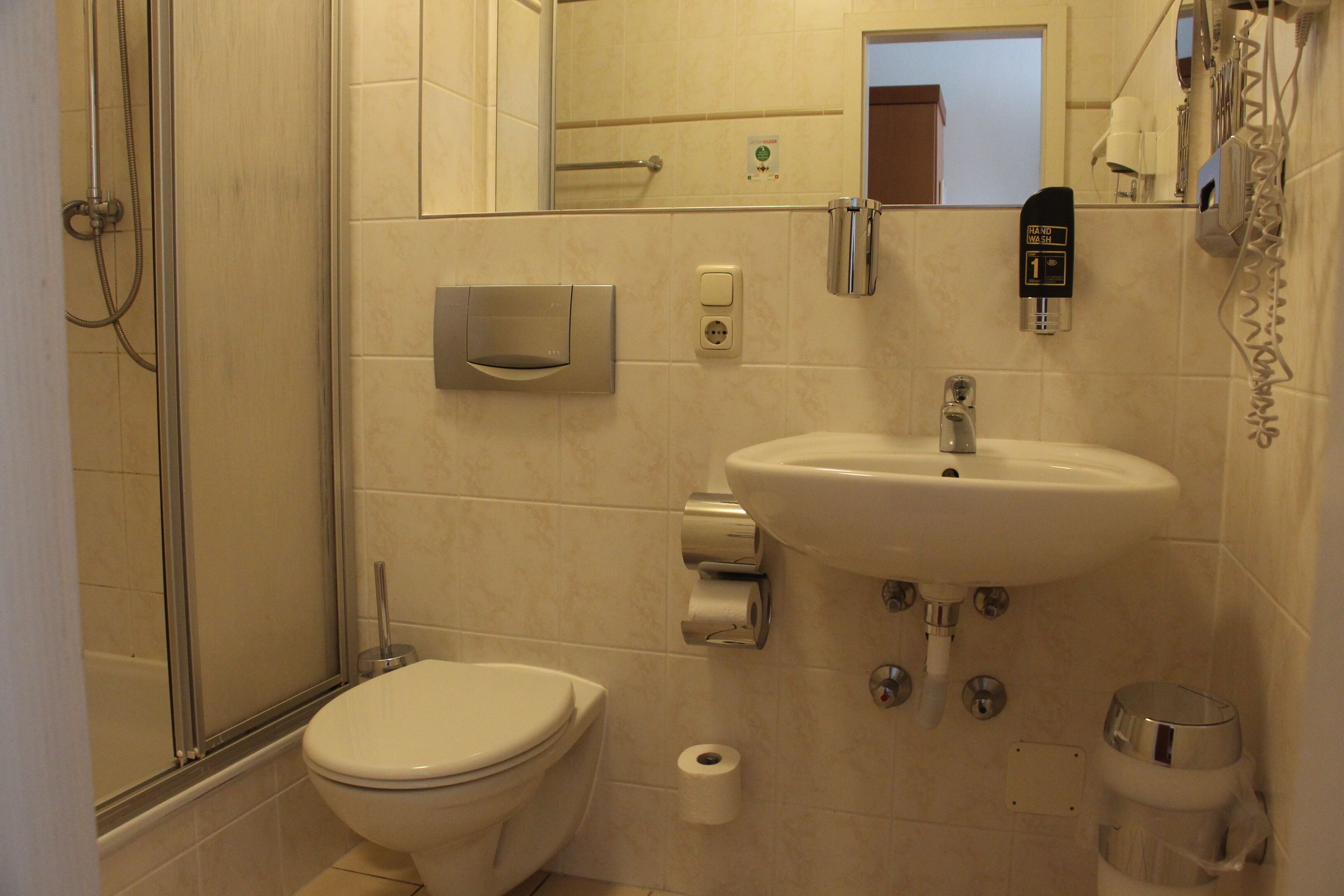 A bathroom with a toilet, sink, and shower.