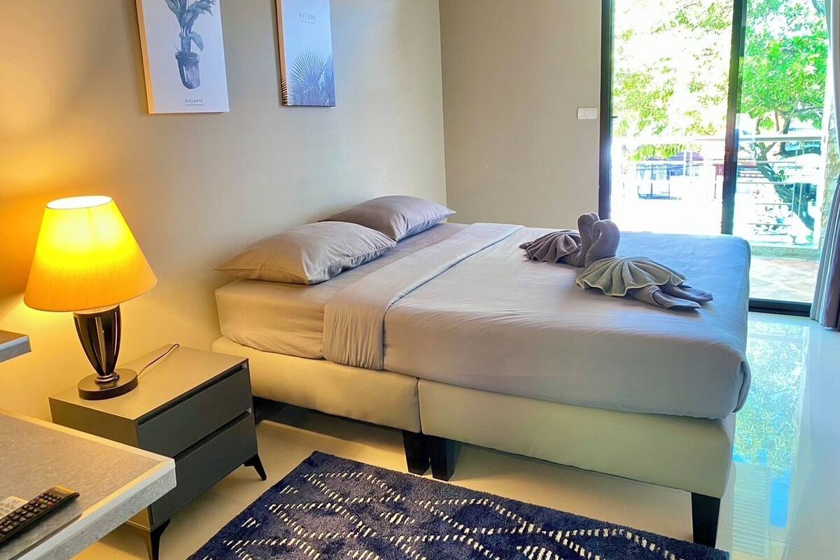Ein Schlafzimmer mit Bett, Nachttischlampe und einem Bild an der Wand.