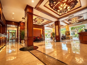 A spacious lobby with marble flooring, wooden columns, and a chandelier. - Huong Sen Hotel (Ho Chi Minh City)
