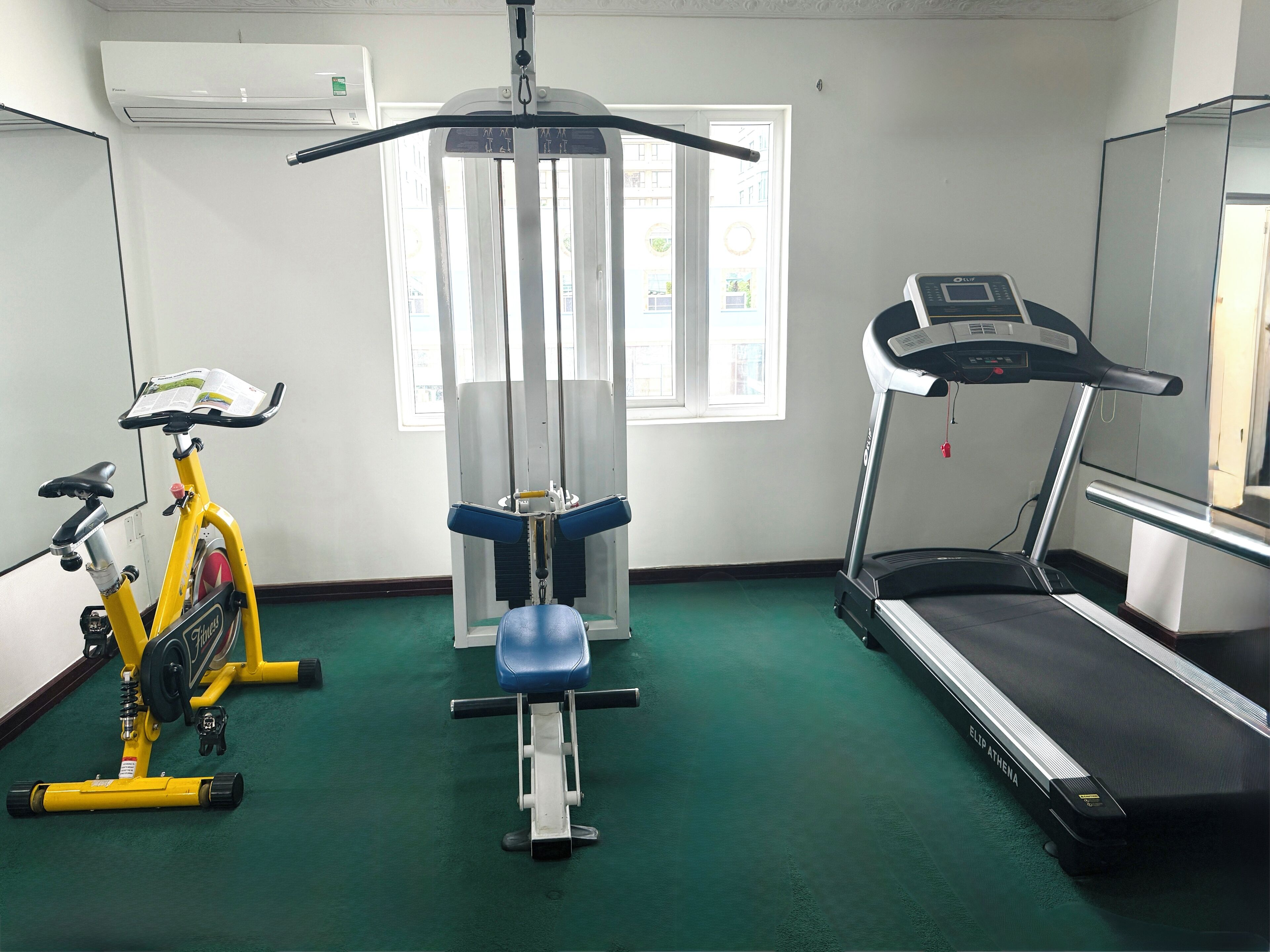 Una palestra con una cyclette, un vogatore e un tapis roulant.