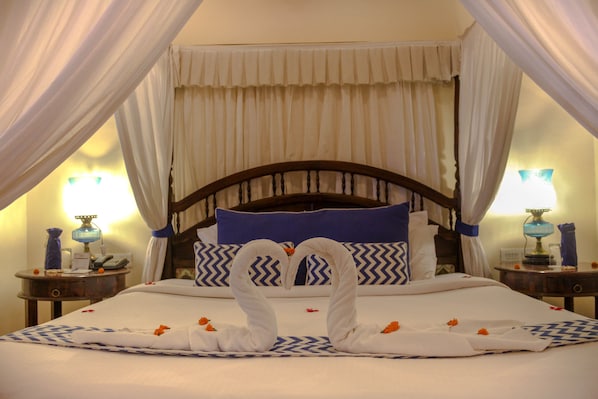 Una cama con dosel, un almohadón azul y un cabecero de madera.