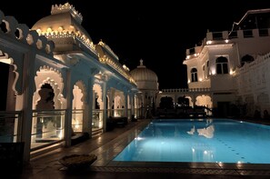 Relax by the serene pool surrounded by traditional architecture and ornate details.