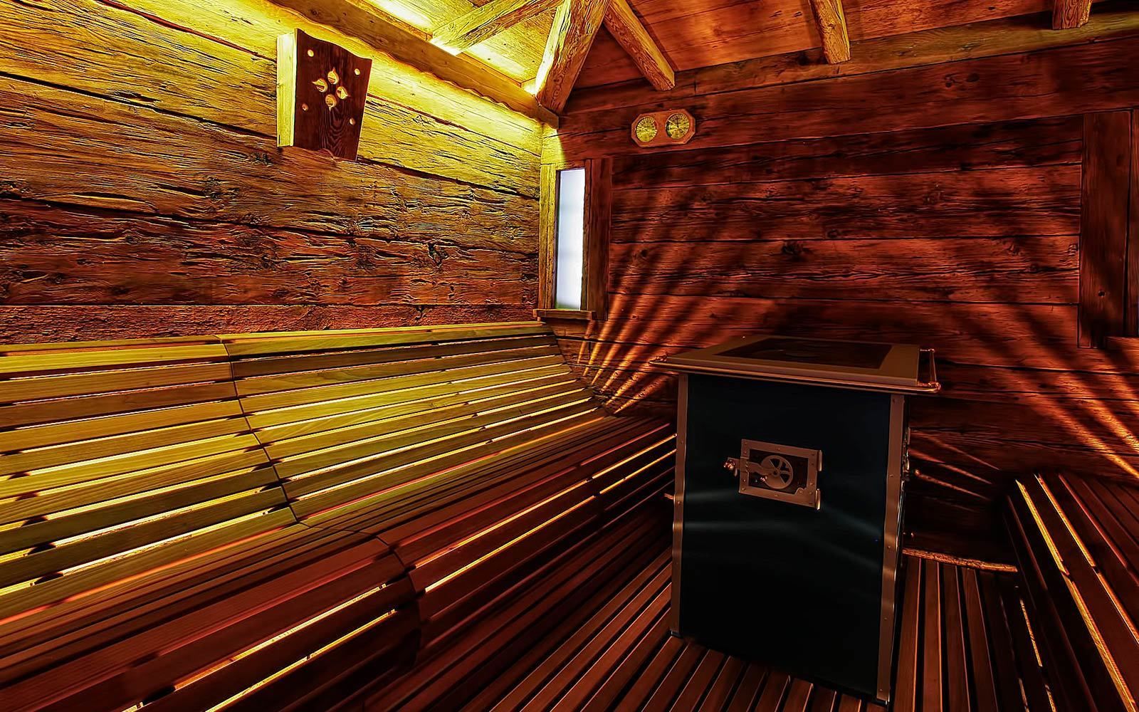 A sauna room with wooden benches and a small cabinet.