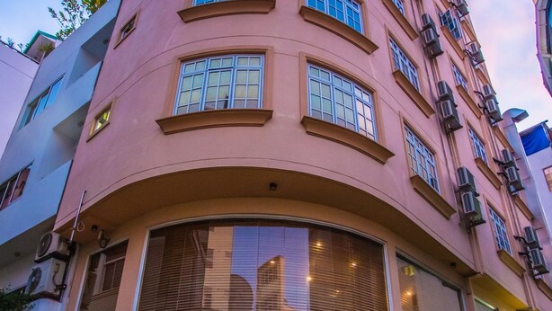A multi-story hotel with a curved facade, large windows, and balconies. - Hotel Octave (Malé)