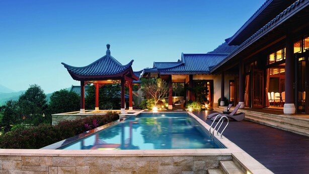 A traditional building with a pool and a view of mountains. - Imperial Springs (Guangzhou)