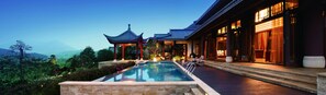 A traditional building with a pool and a view of mountains. - Imperial Springs (Guangzhou)