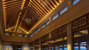 A spacious lobby with a high ceiling, a central seating area, and a reception desk. - Imperial Springs (Guangzhou)