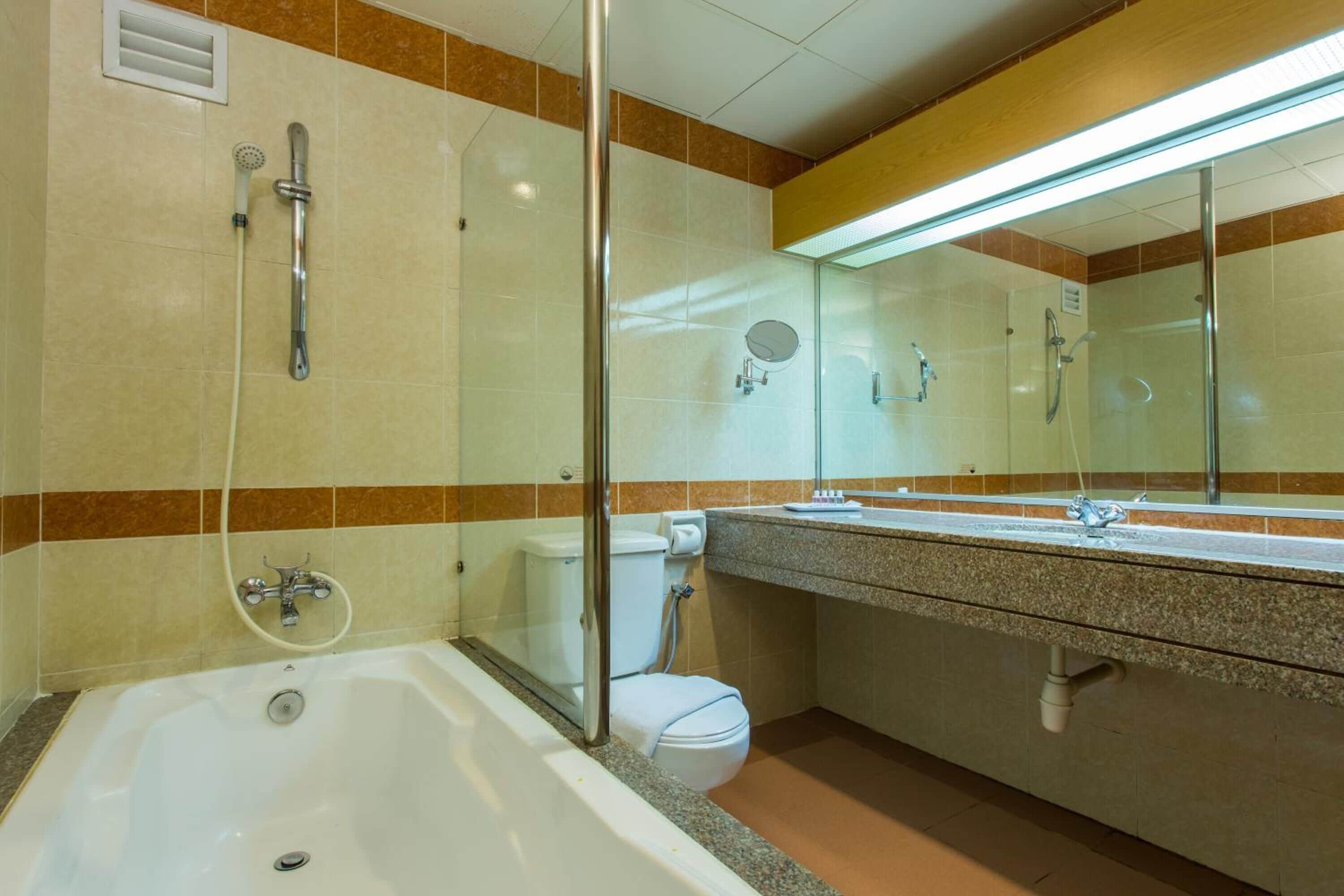 Uma casa de banho moderna com banheira, sanita e área de duche com divisória de vidro.