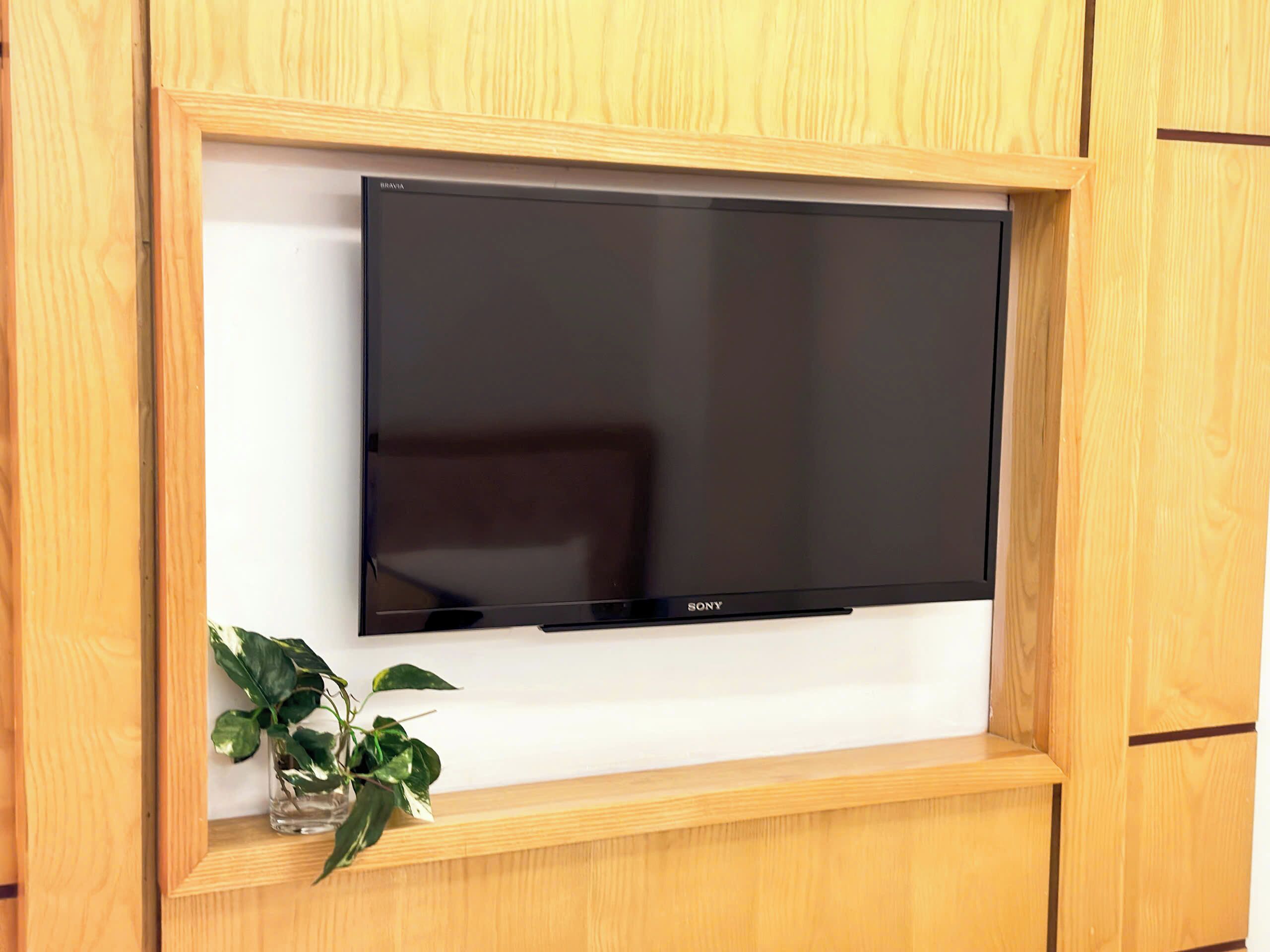 Un televisor de pantalla plana montado sobre un mueble de madera.