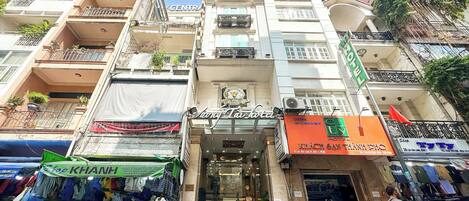 A hotel with a central entrance, multiple balconies, and a sign for 'City Hotel'.