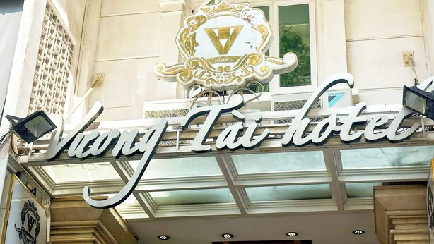 Une enseigne d’hôtel ornée d’un blason et portant le nom « Vang Ta Hotel ».