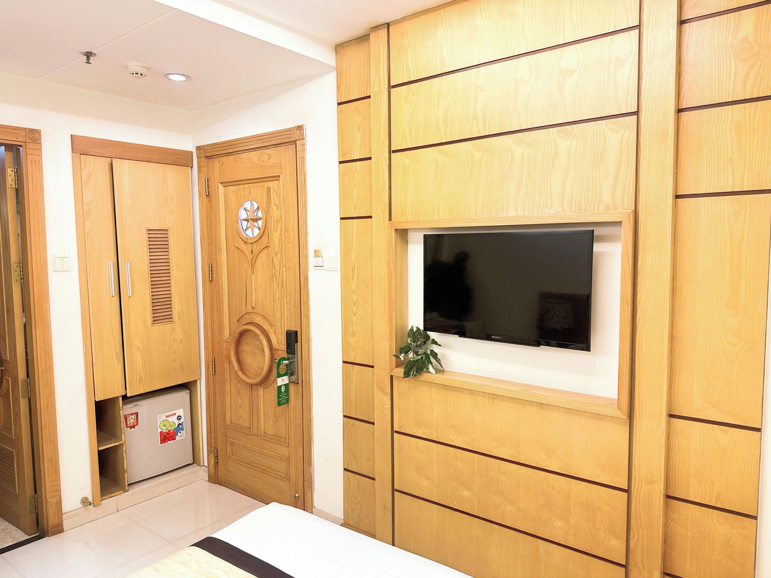 A room with wooden cabinetry, a built-in TV, and a small window.