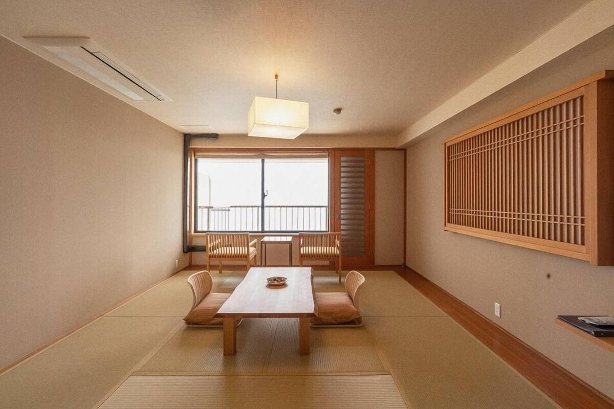 Een traditionele Japanse kamer met tatami vloerbedekking, een lage tafel en verschuifbare deuren.