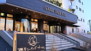 Exterior del Hotel Isohara Seaside, con una entrada destacada, escalones que conducen a ella y un cartel con el nombre del hotel.