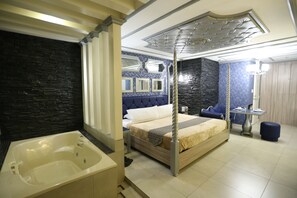 A modern hotel room with a large bed, a separate bathroom, and a dining area. - Victoria Court Suites - Pasig (Pasig)
