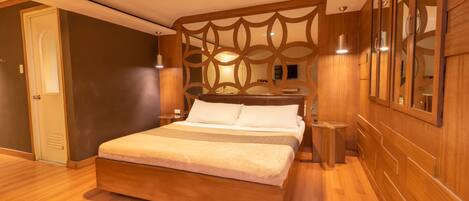 Un dormitorio moderno con una cama de madera, un cabecero decorativo y un espejo grande en la pared.