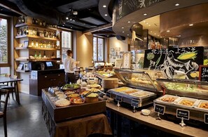 Een buffetgedeelte met diverse gerechten en een bar met flessen op planken.