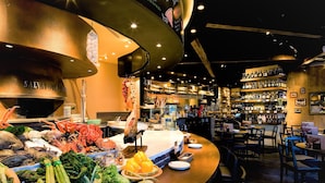 A seafood display with various fresh fish and shellfish, a bar area with shelves of bottles, and a seating area with tables and chairs. - Daiwa Roynet Hotel Sapporo Susukino (Sapporo)