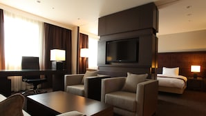 A hotel room with a flat-screen TV, a sofa, a desk, and a bed. - Daiwa Roynet Hotel Sapporo Susukino (Sapporo)