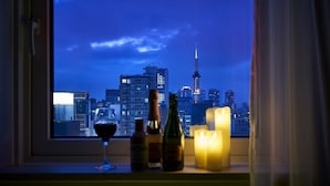 A window view of a cityscape at night with a prominent tower, candles, and bottles on the windowsill. - Daiwa Roynet Hotel Sapporo Susukino (Sapporo)