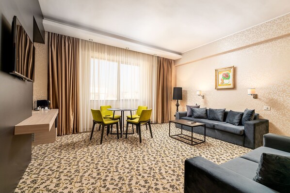 Une chambre d’hôtel avec un coin repas, un canapé et une machine à café.