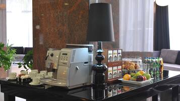 Een ontbijtbuffet met een koffieapparaat, een lamp en een presentatie van fruit en sap.