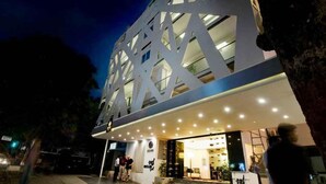 En moderne bygning med en markant geometrisk facade og en godt oplyst indgang.