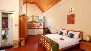 Un dormitorio con cama de madera, una mesita de noche, una manta verde y una escalera que lleva a un nivel superior.