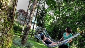A hammock in a lush green outdoor setting. - Ambady Estate (Devikolam)
