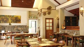 Un comedor amplio con mobiliario de madera y un techo alto.