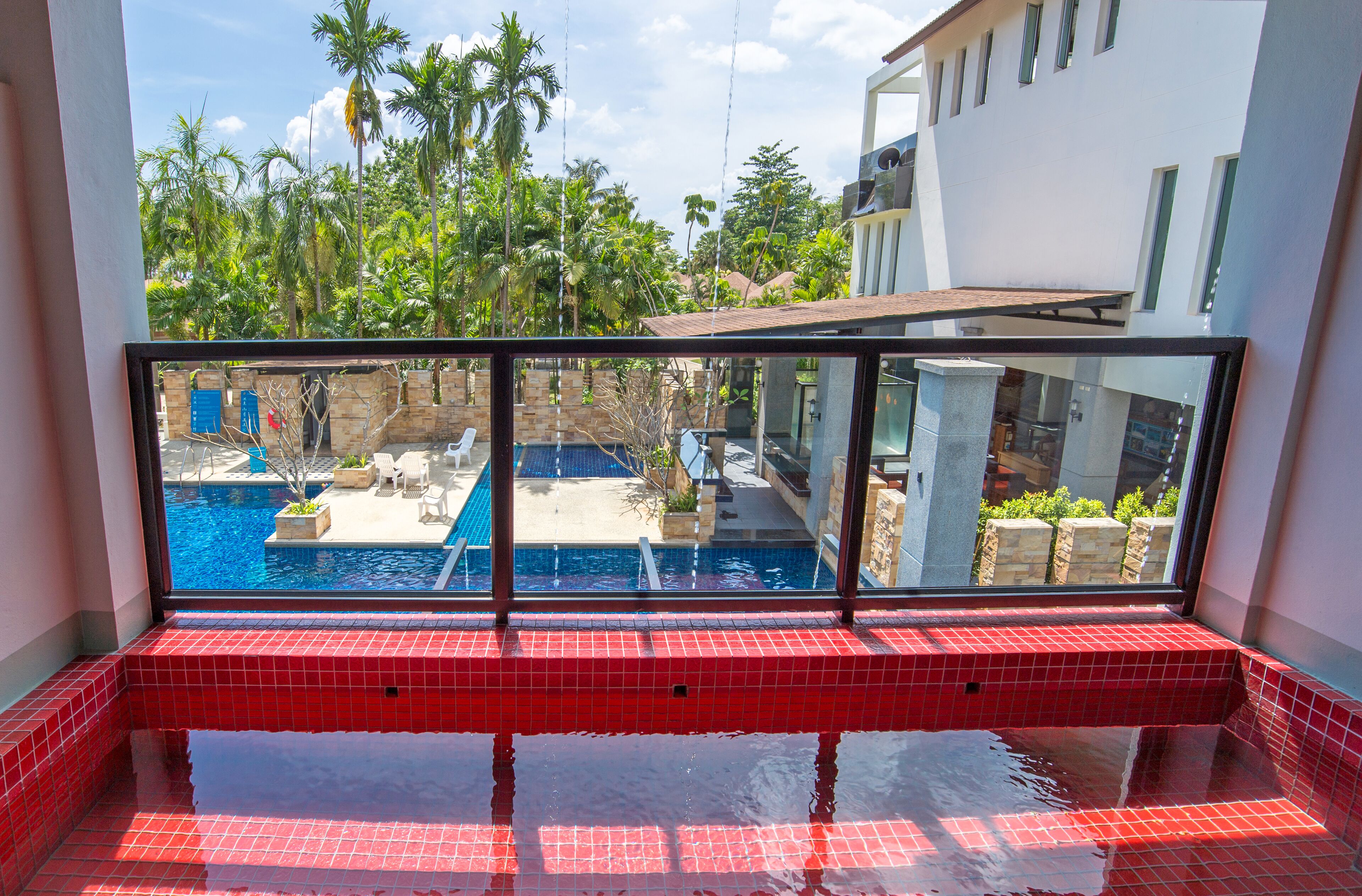 A pool area with a view of a swimming pool and palm trees.