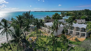 A resort with multiple white buildings, a beach, and palm trees. - Coral Azur Beach Resort (Mont Choisy)