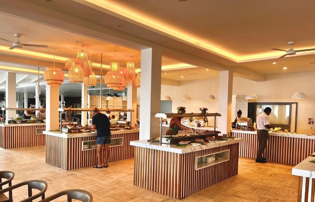 Un restaurante moderno con varios mostradores, iluminación cálida y un amplio espacio.